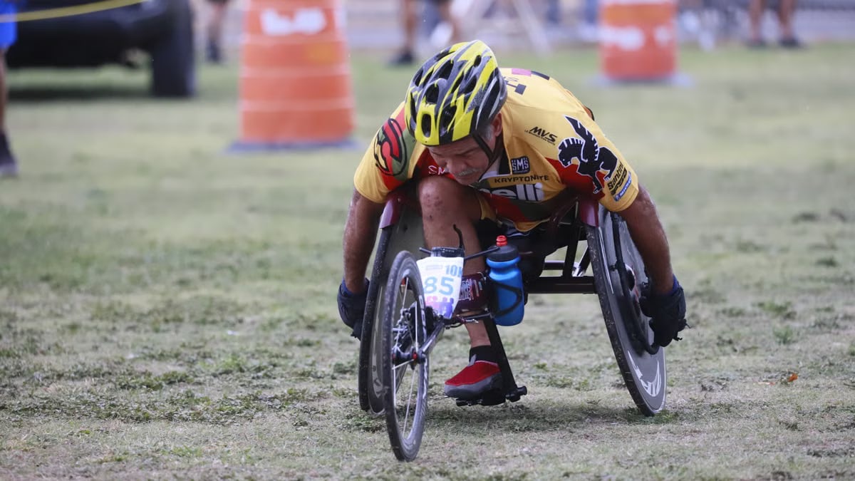 Determined wheelchair racer competing in an outdoor marathon, displaying focus and athleticism.